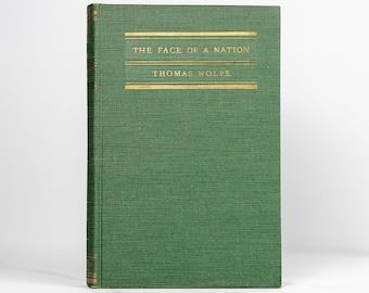 Puede incluir: Un libro de tapa dura verde con letras doradas en el lomo y la portada. El título es "The Face of a Nation" de Thomas Wolfe.