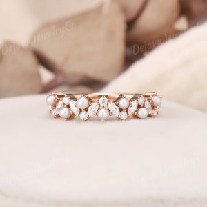 This vintage-inspired pearl wedding ring is a unique and elegant choice for a timeless bride.  Designed as a stackable ring, it can be worn alone or paired with other pieces for a personalized look. vintage charm and modern sparkle.