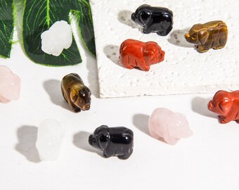 May include: A collection of ten small pig figurines carved from various types of stone. The figurines are in a variety of colors, including black, white, brown, red, and pink.