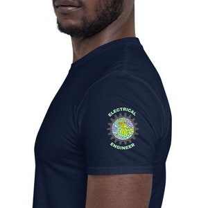 Puede incluir: Una camiseta azul marino con un gráfico verde y amarillo en la manga derecha. El gráfico es un engranaje con las palabras "Electrical Engineer" alrededor.