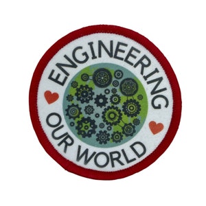 May include: A white round patch with a red border. The patch has a green and blue globe with black gears on it. The text "ENGINEERING OUR WORLD" is around the globe. There are two red hearts on either side of the globe.