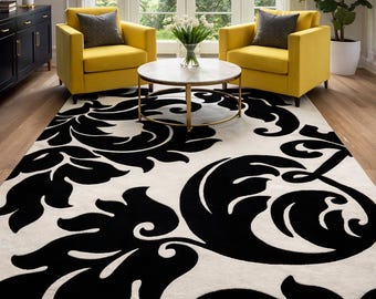 May include: A large, rectangular area rug with a cream background and a bold, black floral pattern. The rug is the focal point of a living room setting, complemented by yellow armchairs, a round coffee table, and a black cabinet.