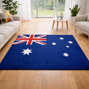 Puede incluir: Una alfombra rectangular azul con el diseño de la bandera australiana. La alfombra tiene la Union Jack en la esquina superior izquierda y estrellas blancas sobre un fondo azul. Está colocada sobre un suelo de madera, adecuada para un salón.