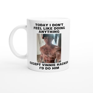 Può includere: Una tazza in ceramica bianca con testo nero che recita "Oggi non ho voglia di fare niente tranne Vinnie Hacker, lo farei". La tazza presenta una foto di un uomo senza maglietta con dei tatuaggi.
