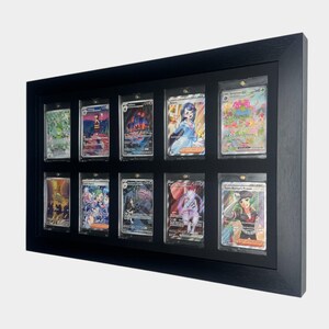 May include: A black wooden display frame holding twelve collectible trading cards. Each card is encased in a clear protective sleeve. The cards feature colorful illustrations and text, showcasing a variety of characters and scenes.