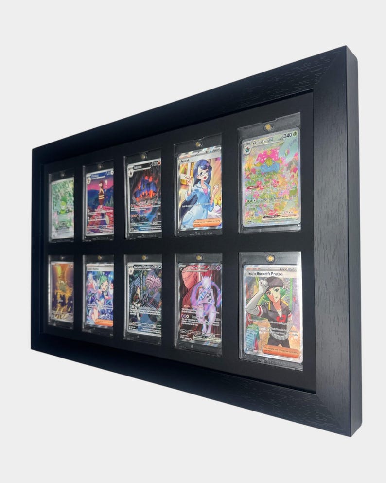 May include: A black framed display case holding ten trading cards. The cards are in individual protective sleeves. The cards feature colorful illustrations of various characters and creatures. The frame is rectangular and made of wood.