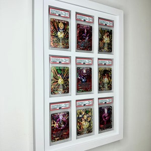 May include: Nine Dragon Ball Super trading cards are displayed in a white frame. The cards are graded and encased in protective plastic. The cards feature various characters from the Dragon Ball Super anime series.