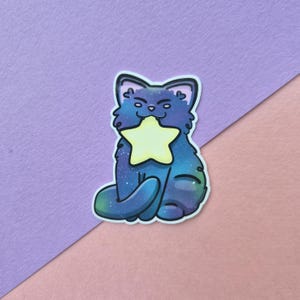 Klistermärke med galaxkatt som håller en stjärna | Glansigt vinyldekal med kosmisk kattunge
