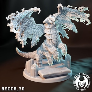 Pode incluir: Uma figura detalhada de dragão cinza claro com grandes asas texturizadas e uma cauda pontiaguda. O dragão está posicionado em uma plataforma de pedra com pilares. A base inclui o texto "BECCA_3D" e um logotipo "KAIJUMON MINIS".