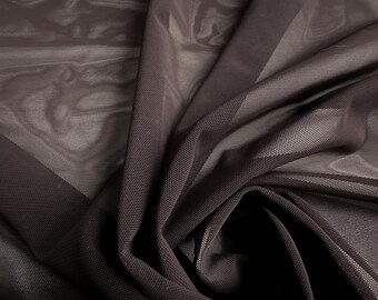 May include: Close-up of a dark brown sheer mesh fabric with a fine, open weave. The fabric is draped and folded, creating shadows and highlights. The material has a soft, flowing appearance, suitable for apparel or decorative projects.