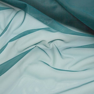 May include: A sheer, lightweight fabric in a deep teal colour, featuring a fine mesh texture. The material is draped in soft, flowing folds, creating varying levels of transparency and depth across the surface of the textile.