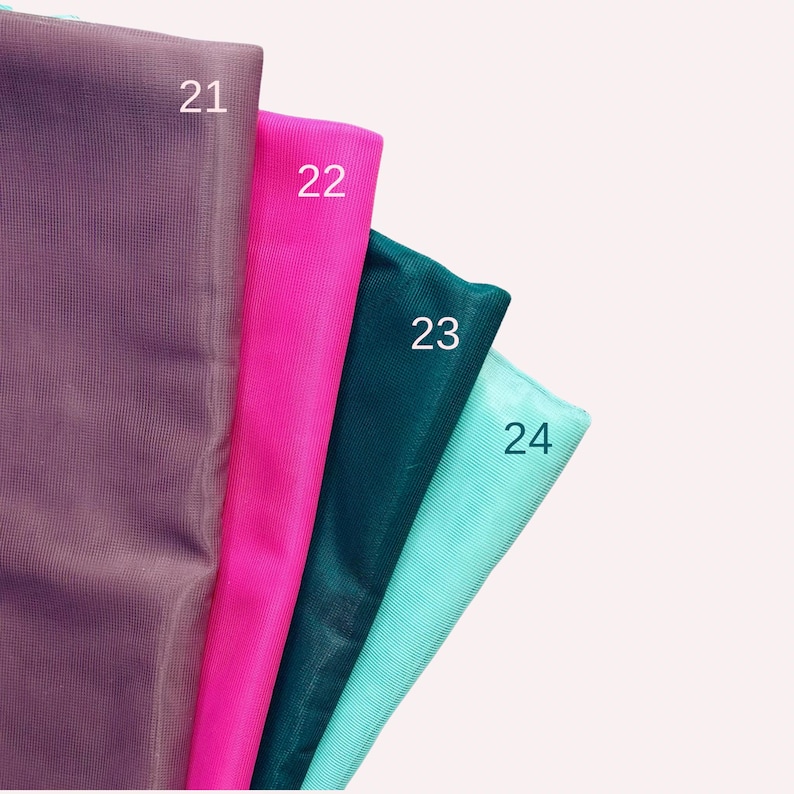 May include: Four folded fabric swatches arranged in a row, featuring a fine mesh texture. The colours from left to right are dark purple, bright pink, deep teal, and light mint green, labelled with the white numbers 21, 22, 23, and 24.