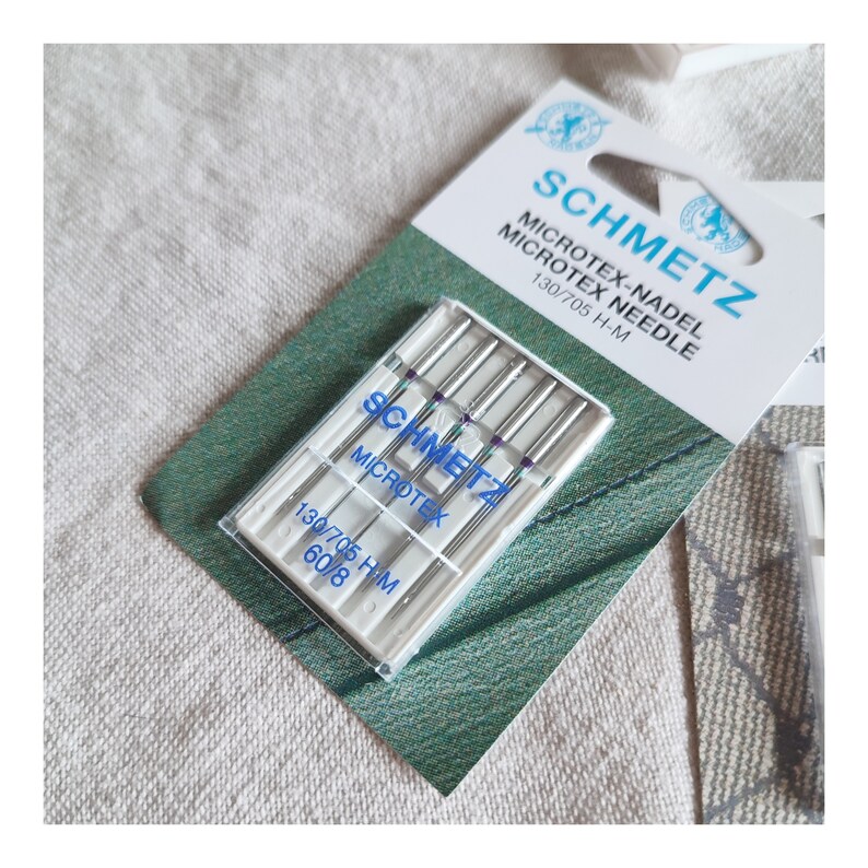 Puede incluir: Un paquete de agujas para m&aacute;quina de coser de tama&ntilde;o 60/8, etiquetado como "Schmetz Microtex-Nadel Microtex Needle 130/705 H-M".