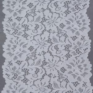 May include: A strip of white lace fabric featuring a repeating floral pattern with scalloped edges. The intricate design consists of interconnected petals and leaves created with fine thread, forming a delicate openwork mesh texture throughout.