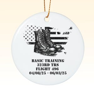 May include: White ceramic ornament with a black and white illustration of military boots on a distressed American flag background. The text "BASIC TRAINING 323RD TRS FLIGHT 496 04/08/25 - 06/03/25" is printed below the illustration.