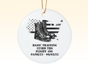 Könnte beinhalten: Weißer Keramik-Anhänger mit einer Schwarzweiß-Illustration von Militärstiefeln auf einem verwitterten amerikanischen Flaggenhintergrund. Der Text "BASIC TRAINING 323RD TRS FLIGHT 496 04/08/25 - 06/03/25" ist unter der Illustration gedruckt.