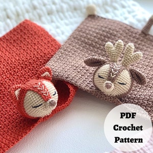Peut inclure: Deux couvertures pour b&eacute;b&eacute; en crochet avec des applications d'animaux. Une couverture est orange avec une application de renard et l'autre est marron avec une application de renne. Les couvertures sont sur une surface blanche avec le texte "PDF Crochet Pattern" dans un cercle.
