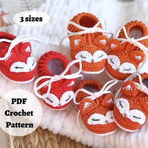 May include: Crochet pattern for fox baby booties in red and orange with white laces. The pattern includes three sizes. The text "PDF Crochet Pattern" is on a white circle.