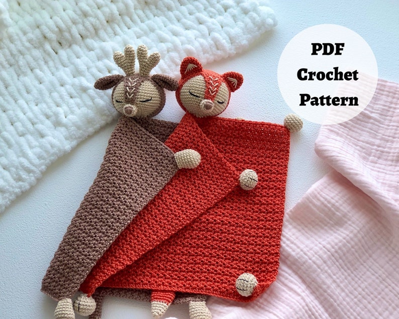 Peut inclure: Un mod&egrave;le de crochet pour une couverture b&eacute;b&eacute; avec un jouet amigurumi de cerf et de renard. La couverture est marron et orange et les jouets sont beiges avec des yeux marrons. Le mod&egrave;le est disponible en t&eacute;l&eacute;chargement PDF. Mod&egrave;le de crochet PDF