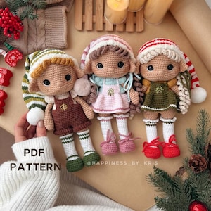 Puede incluir: Tres muñecas elfo de crochet con atuendos y sombreros de diferentes colores. Las muñecas están sentadas sobre una superficie marrón con una rama de pino verde y un adorno rojo. El texto "PDF PATTERN" es visible en la esquina inferior izquierda de la imagen.