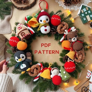 Può includere: Una ghirlanda natalizia fatta a mano con ornamenti all'uncinetto, tra cui un pupazzo di neve, un pinguino e una renna. La ghirlanda presenta elementi rossi, bianchi, verdi e marroni, con il testo "PDF PATTERN".