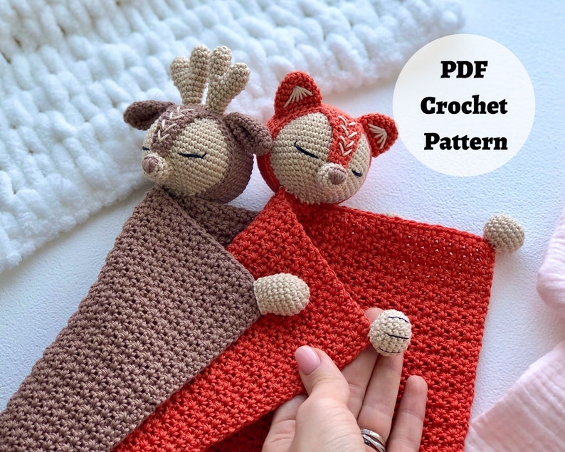 Peut inclure: Un mod&egrave;le de crochet pour une couverture de b&eacute;b&eacute; avec une applique de cerf et de renard. La couverture est rouge et marron avec un fond blanc. Le mod&egrave;le est disponible en t&eacute;l&eacute;chargement PDF.