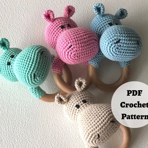 Op de afbeelding: Haakpatroon voor een nijlpaard rammelaar. Het patroon bevat drie verschillende kleurvariaties: roze, lichtblauw en beige. Het patroon is beschikbaar als PDF-download.