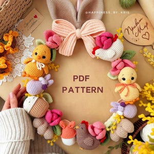 Könnte beinhalten: Ein handgefertigter Häkelkranz mit einer Hasenohrenschleife, Blumen, Küken und Hasen. Der Kranz ist mit rosa, orangefarbenen und lila Elementen verziert. Der Text "PDF PATTERN" ist in der Mitte des Kranzes zu sehen.