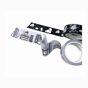 May include: Three rolls of washi tape with cute illustrations of ghosts, books, and a cat. The tape is black and white with a glittery finish.