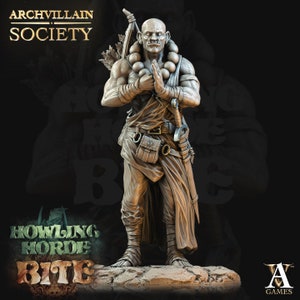 May include: A detailed miniature figurine of a bald, muscular, humanoid figure wearing a brown robe and holding a staff. The figure has a beaded necklace and a belt with a pouch. The figure is standing on a rocky base.