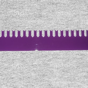 May include: A purple plastic knitting gauge with 20 rows of teeth. The gauge is used to measure the size of knitting needles and the gauge of knitted fabric.