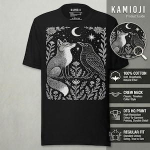 Puede incluir: Camiseta negra de cuello redondo con una ilustraci&oacute;n blanca de un zorro y un cuervo enfrentados, rodeados de flores y estrellas. La camiseta tiene el texto "KAMIOJI" en la parte superior. Impresa en algod&oacute;n.