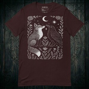 Linocut folk art design, fox and crow under a celestial crescent moon. Oxblood black color variation.