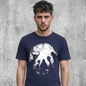 Male wearing a Cryptid horror t-shirt, unisex fit with a crew neck collar, 100% cotton. Navy color variation.