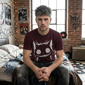 Trippy black cat shirt with alt fashion vibes. A Tim Burton–inspired gothic tee for fans of creepy cute and grunge styles. Oxblood black color variation, crew neck.