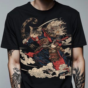 May include: Black t-shirt featuring a detailed illustration of a cat samurai in traditional Japanese armor, wielding a katana. The design includes clouds and a fierce expression, with a blend of red, blue, and gold accents.