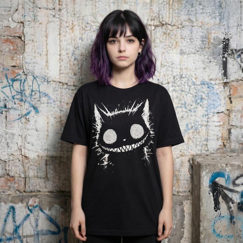Creepy Cheshire Cat tshirt with hypnotic eyes. High contrast white ink on black. Unisex, crew neck, 100% cotton. Alternative clothing.