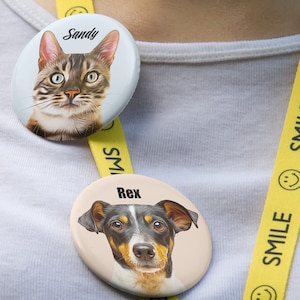 May include: Two round, white button badges with yellow trim. The top badge features a cat with brown tabby markings and the text "Sandy". The bottom badge features a black and brown dog with the text "Rex".