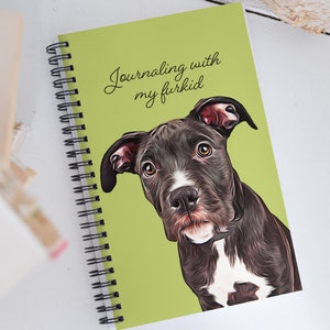 May include: A green spiral bound journal with the text "Journaling with my furkid" printed on the front cover. A black and white dog with a white patch on its chest is pictured on the cover.