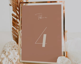 May include: A gold-framed table number sign with a brown background and white text. The sign reads "Table no. 4".