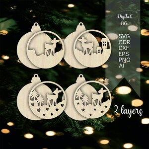 Könnte beinhalten: Vier hölzerne Weihnachtsbaumschmuck-Ausschnitte mit Hirsch- und Baummotiven. Die Ornamente sind für einen 3D-Effekt geschichtet. Der Text "2 Schichten" ist im Bild sichtbar.