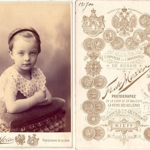 Um retrato impressionante de uma menina pequena e linda com um olhar penetrante. Ucrânia. Kiev. Frans De Mezer. Década de 1900. Cartão Cadinet antigo original.