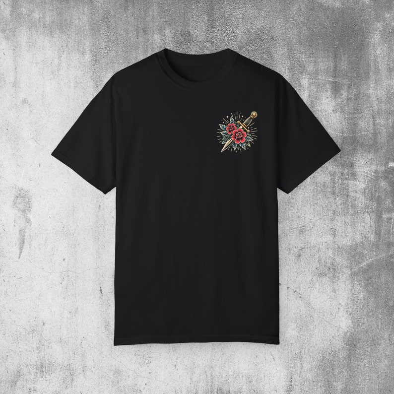 Puede incluir: Camiseta negra con un gr&aacute;fico de una daga y rosas en el pecho izquierdo.