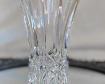 May include: A clear glass vase with a square opening and a cut glass design. The vase is approximately 6 inches tall.