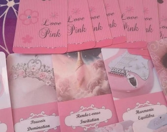 May include: A collection of pink tarot cards with floral and text designs. The cards feature the words "Love Pink" and other French phrases. The overall theme is romantic and feminine, with a soft color palette.