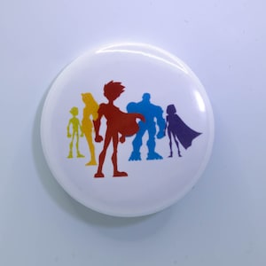 Puede incluir: Un botón blanco con una silueta de color de cinco superhéroes. Los superhéroes están en línea, con el superhéroe rojo en el centro. Los superhéroes son amarillo, rojo, azul, morado y verde.