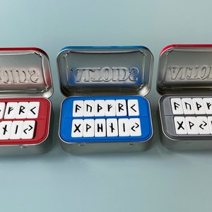Rune Set inside Altoids tin boxes showing three color options. Red, Blue and Grey.