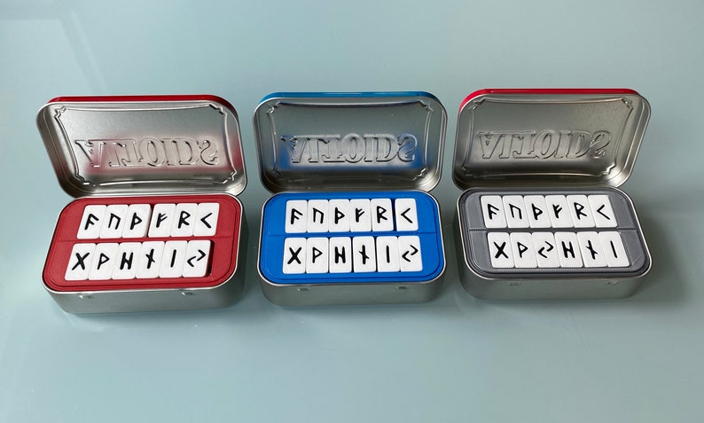 Rune Set inside Altoids tin boxes showing three color options. Red, Blue and Grey.