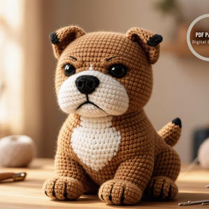 Puede incluir: Un cachorro de bulldog marrón y blanco tejido a ganchillo con detalles en negro. El perro hecho a mano tiene un pecho blanco, una nariz negra y orejas y cola con punta negra. La imagen incluye el texto "PDF PATTERN Digital Download".