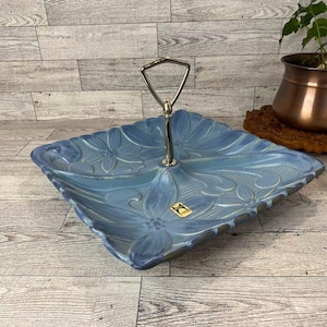 Può includere: Un vassoio da portata in ceramica blu con un motivo floreale e un manico argentato. Il vassoio è diviso in quattro sezioni.